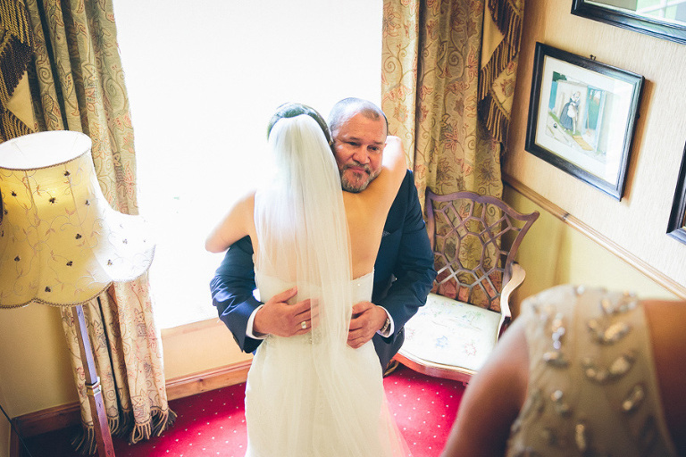 father of the bride hugging bride